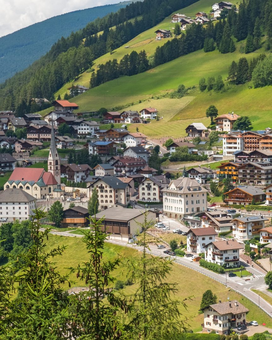 Santa Cristina Val Gardena — veduta del paese con il campanile e le case tra i prati verdi a 1.428 m